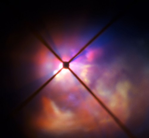 Staubwolken um VY Canis Majoris - das schwarze Kreuz ist ein Schatten des Meßinstruments am Teleskop (Bild: ESO)